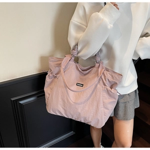 Détail de la poignée en nylon nouée et de l'anneau métallique sur le sac fourre-tout