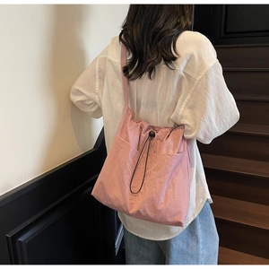 Detail view of pink large capacity nylon bucket bag with drawstring closure for daily use