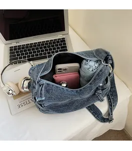 Detail view showing spacious interior of blue denim bag with phone, wallet and umbrella