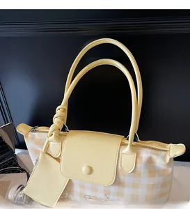 Detailed view of yellow plaid tote bag with faux leather handle and mini hanging pouch