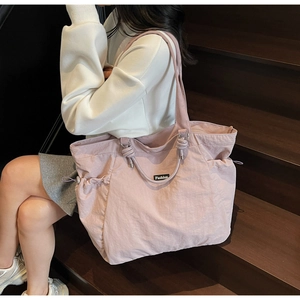 Détail d'un sac cabas en nylon rose violet avec poches latérales à cordon réglable
