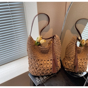 Détail d'un sac en paille tressée avec gland à franges et bandoulière en cuir