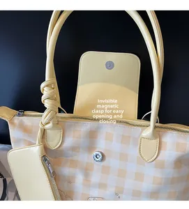 Detail view of canvas tote bag featuring hidden magnetic closure and small hanging pouch