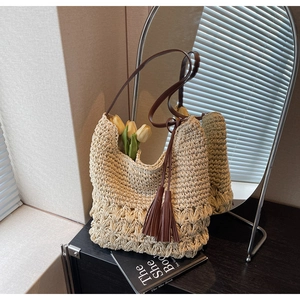 Détails de la texture du sac cabas tissé avec bandoulières en cuir et ornements glands
