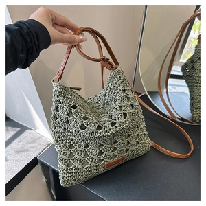 Detail of green knit crossbody bag with woven wave pattern and brown leather strap