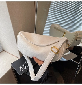 Vista dettagliata della borsa a mezzaluna in pelle bianca con fibbia dorata e zip sul retro