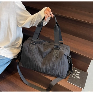 Close-up of black multifunctional travel bag with textured fabric on wooden stairs