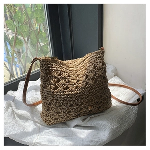 Detail of bohemian hollow diamond weave texture and brown leather strap on straw bag
