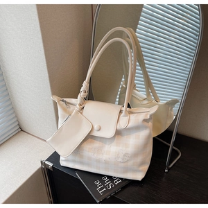 Detail of white checkered tote bag with cute cartoon embroidery and matching pouch attachment