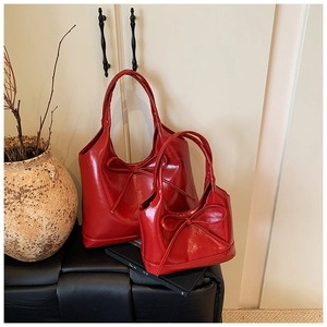 Detailed macro view of red oil wax leather tote bags with elegant bow decoration