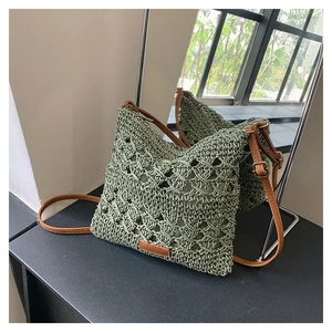 Macro detail of green crochet crossbody bag with woven texture and brown leather strap