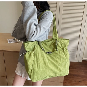 Détail du sac cabas en nylon plissé vert clair avec poche à cordon et étiquette mode