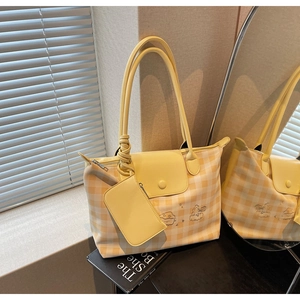 Detailed view of yellow plaid tote bag with embroidery and matching small side pouch