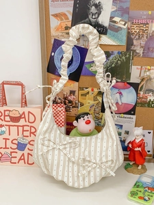 Striped canvas shoulder bag with decorative bows and ruffled handle in cream and beige
