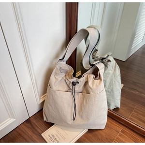 Detail view showing textured nylon surface with wide strap and drawstring closure