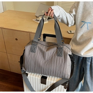 Detailed close-up of dark grey pleated canvas tote bag with reinforced handles and strap