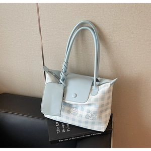Detail of light blue checkered tote bag with a small pouch and cute cartoon embroidery