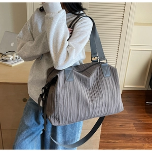 Detail of grey pleated canvas tote bag with reinforced handles and wide nylon shoulder strap