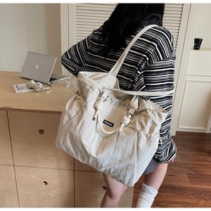 Détails de ce grand sac fourre-tout en nylon avec poignée nouée et poche latérale