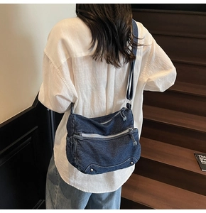 Rear view of a model wearing a large vintage navy denim crossbody tote bag on stairs