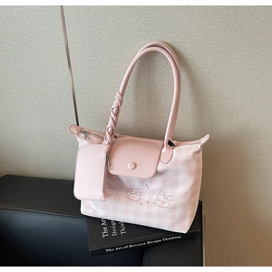 Detail of pink plaid tote bag featuring cartoon bunny embroidery and matching charm pouch