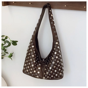 Detailed view of silver rivets and matte leather texture on dark brown hobo bag