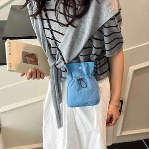 Blue drawstring bucket bag with floral patterned strap for women in minimalist style