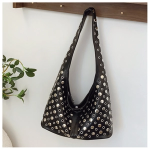 Detailed view of silver metal rivets and round eyelets on a black hobo bag strap