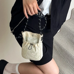 Women's cream white bucket bag with a trendy drawstring design and woven strap