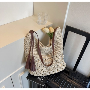 Détail du sac à bandoulière en paille tressé avec longues franges en cuir marron