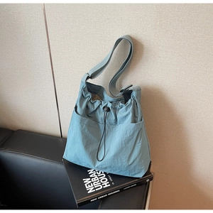 Light blue nylon bucket bag detail with drawstring closure and adjustable strap
