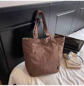 Close-up of brown nylon tote bag showing lightweight textured fabric and durable stitching