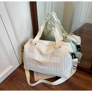 Detail view of cream canvas tote with wrinkled texture and adjustable woven shoulder strap
