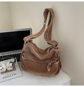 Detail view of washed canvas crossbody bag with double front zippers and wide strap