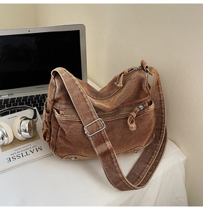 Close-up of vintage brown canvas messenger bag with adjustable strap and metal hardware