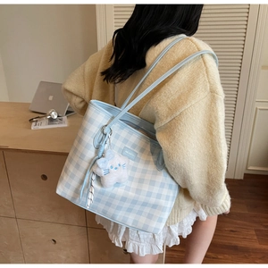 Detail of blue and white checkered tote bag with a white plush star pendant