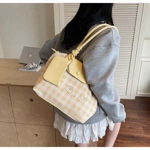 Detail view of yellow plaid tote bag with shoulder strap knot and small zipper coin pouch