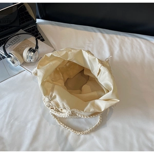 Top view of cream woven bucket bag showing spacious interior with fabric lining