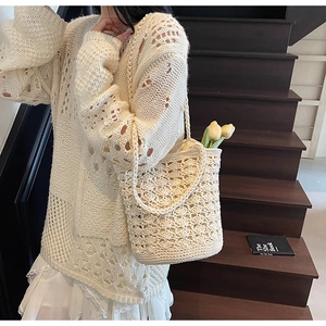 Detailed close-up showing the hollow crochet texture of the beige straw tote beach bag