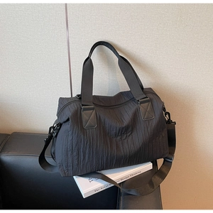 Detailed macro view of black pleated texture fabric on a large capacity canvas tote bag