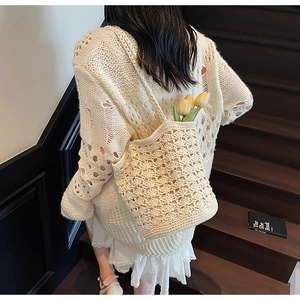 Detail of crochet straw shoulder bag with hollow pattern for beach and vacation