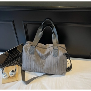 Detail showing deep grey pleated canvas tote bag texture with reinforced handles and strap