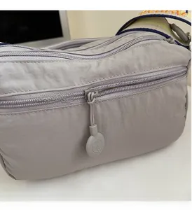 Detail of smooth zippers and durable oxford fabric on the multi-pocket crossbody bag