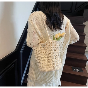 Detailed view of cream hollow knit shoulder bag with bohemian crochet texture and tulips