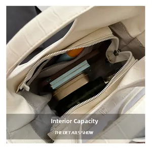 Interior view of crocodile embossed bucket bag showing capacity for phone and cosmetics