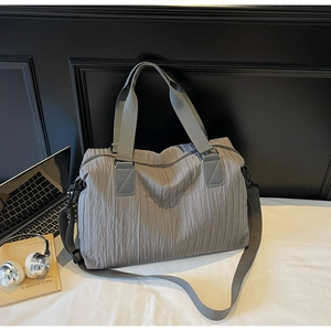 Detail of grey pleated canvas tote bag with nylon handles and adjustable shoulder strap