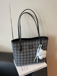 Chic grey plaid tote bag with black leather straps and a plush star charm detail