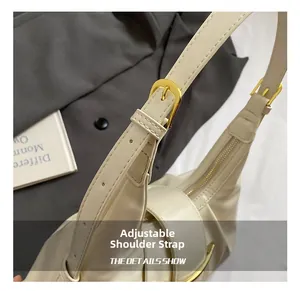 Détail de la bandoulière réglable en cuir crème et de la boucle dorée du sac à bandoulière