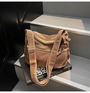Detail of vintage washed canvas crossbody bag with multiple zip pockets and wide strap