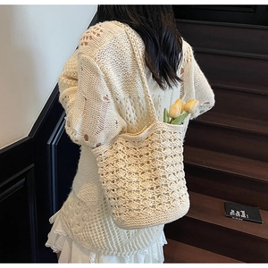 Detailed texture of off-white hollow crochet shoulder bag with spacious bucket design
